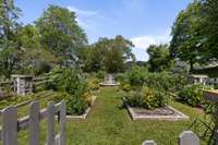 Fenced herb and vegetable garden with antique fountain