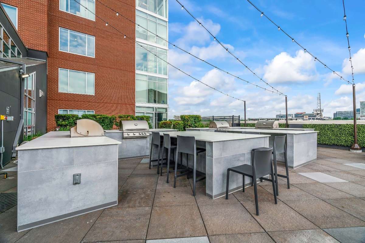Recently renovated Gas Grill area that is inviting to meet your neighbors or serviceable to have a small grilling party of your own. Unit 1101 for sale is two floors above with this view to patio below.