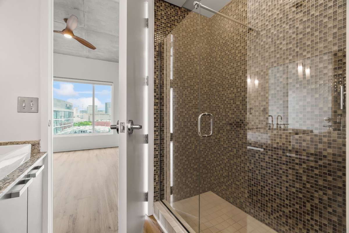 Primary Bedroom's Bathroom with over-sized tiled and glass door shower.