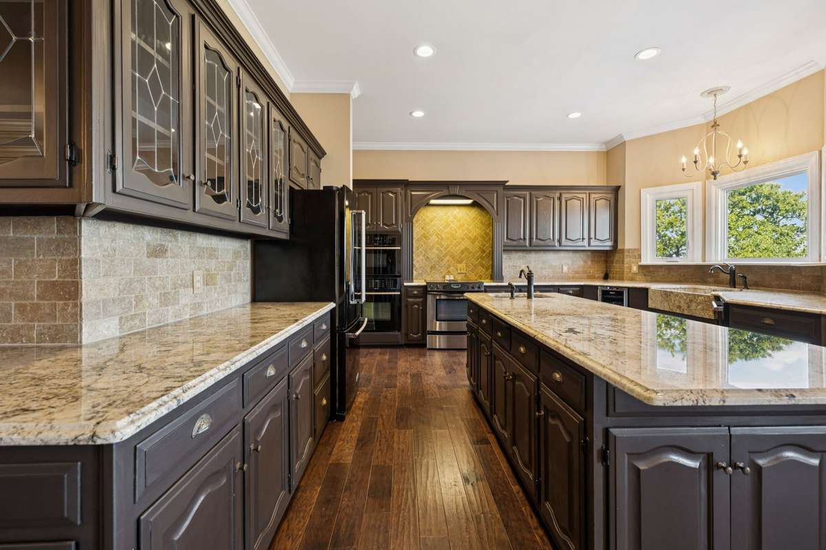 So much counter top and prep area. Glass upper cabinets and tile backsplash.