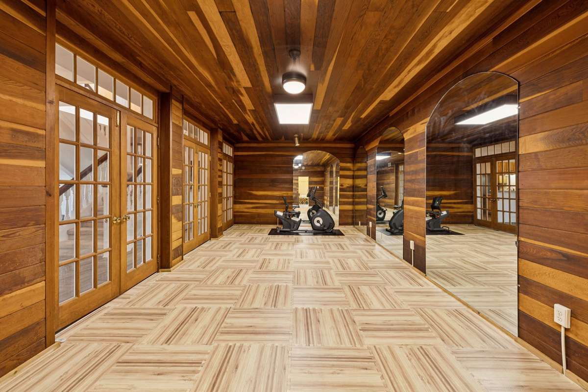 Home gym/ fitness center, Has a mirrored walls and a large shower.