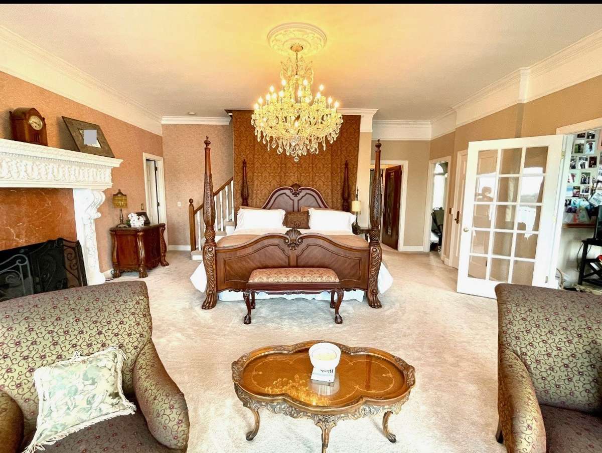 Spacious Owner's Retreat boasting this beautiful chandelier, cozy fireplace, and views of the water!