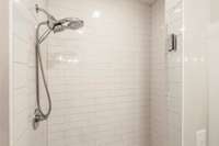 A spacious tile shower with a frameless glass door adds a sleek, modern touch.