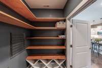 Customized with beautiful blue paint and warm wood shelving, this space is as attractive as it is practical.