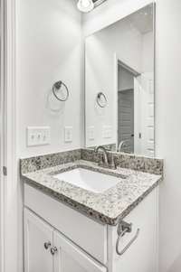 Crisp and clean vanity space featuring granite countertops, brushed nickel fixtures, and bright lighting—perfect for a polished morning routine.