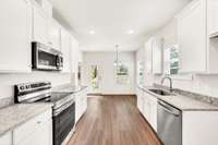 Light-filled dining area extends from the galley kitchen, offering backyard views and easy outdoor access— open feel from prep to patio.