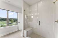 Walk-In Tiled Shower with Bench Seat in Owner's Bath.
Photo is of actual Home.