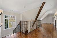 Overlooking the great room, the catwalk offers a stunning vantage point with floor-to-ceiling windows showcasing breathtaking views of Williamson County.