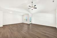 Expansive living area with soaring ceilings and sleek vinyl plank flooring. The open layout offers endless potential—create a cozy lounge, a dining nook, or an entertainment space that truly fits your style.