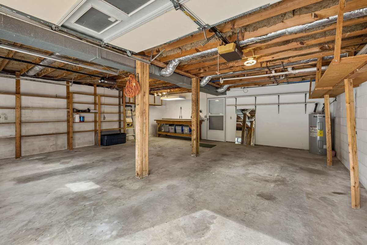 Just off the bonus room, the lower-level, two-car garage features built-in shelving and a dedicated workbench perfect for those who appreciate a well-organized workspace.