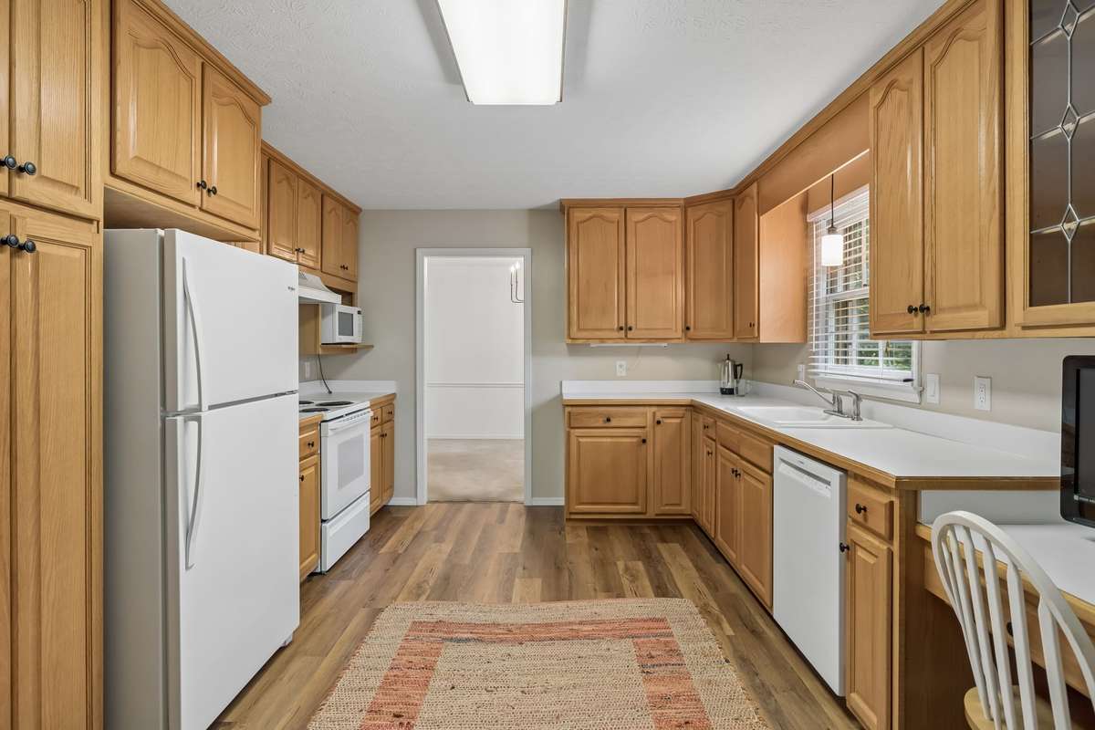 Newly installed, durable vinyl plank flooring, a brand-new Bosch dishwasher, and a pendant over the sink make the space both functional and attractive.