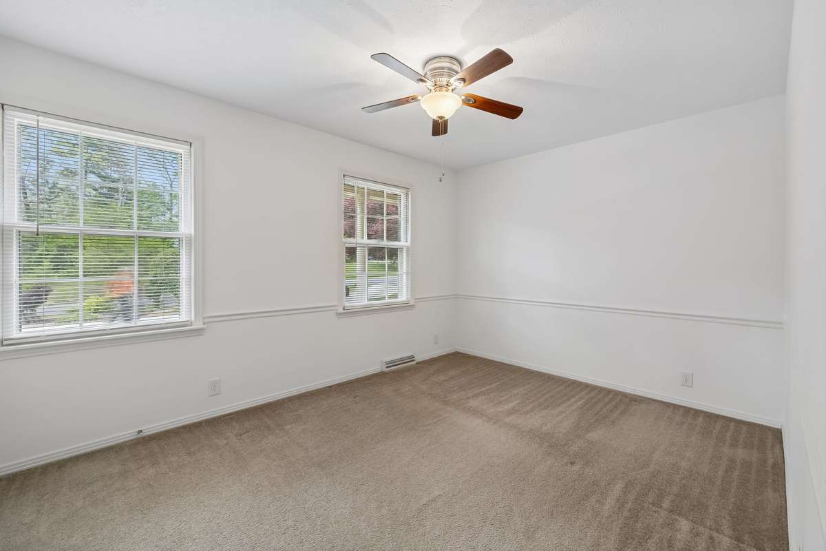 The front middle bedroom provides touches of elegance with chair railing, a cooling ceiling fan, and double windows to welcome the morning sun.