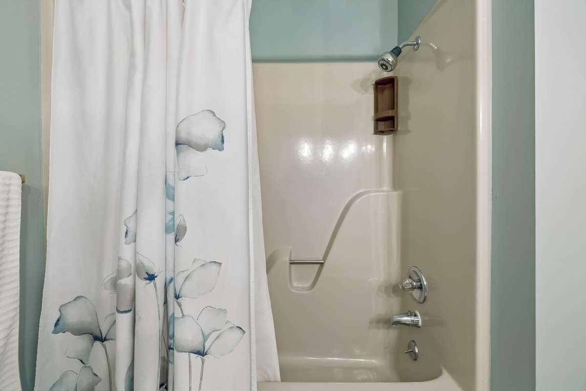 A clean and well-maintained full bath includes a classic shower and tub combination for convenience.