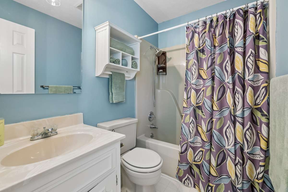 Enjoy the convenience of an en-suite bathroom, elegantly appointed with a crisp white vanity and updated fixtures.