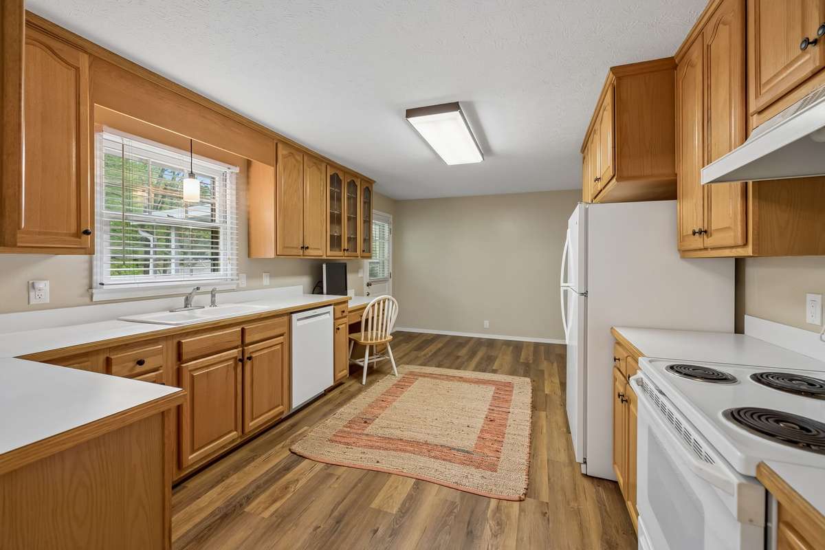 The heart of the home is a spacious kitchen featuring warm oak cabinetry and a charming built-in desk for organized living. A cozy eat-in area creates a delightful spot for casual meals and conversations with friends over coffee.