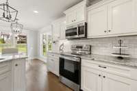 The kitchen features beautiful white shaker style cabinets with soft close.