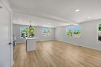 A view of the open kitchen, living, and dining area from back entry.
