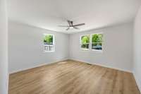 The primary bedroom features a ceiling fan and plenty of natural light.
