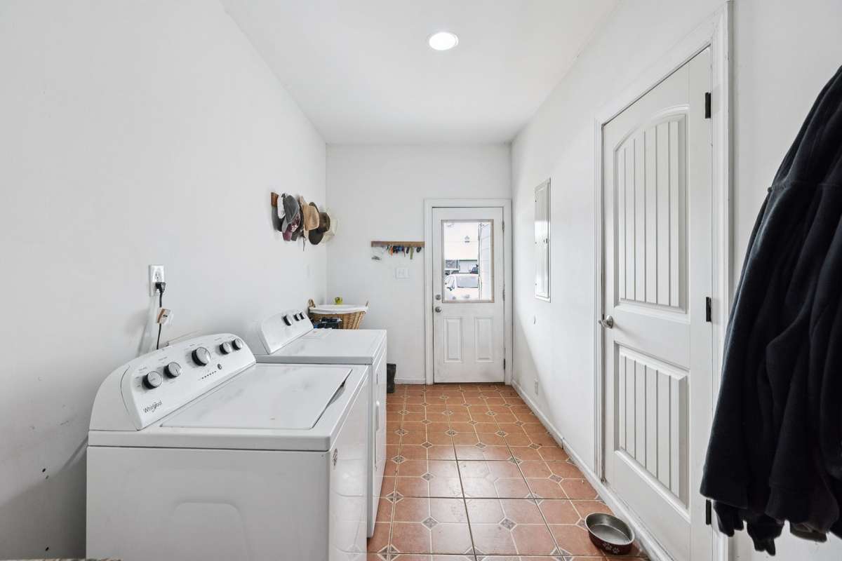Laundry area in main home with side entry door to yard