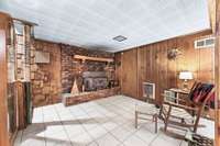 Additional view of the partially finished basement. Notice the wood burning fireplace.  You will absolutely love this space!