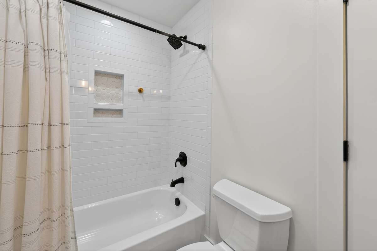 Subway tile shower and tub are located in the hall bath.