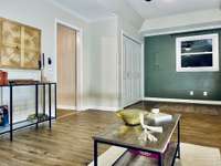 Flex room facing kitchen door, laundry closet and front window. Beautiful green accent wall.