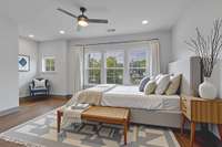 Primary bedroom also offers overhead lighting, ceiling fan, hardwood floors, a large picture window and ensuite bathroom / closet.  **This Photo is Virtually Staged**