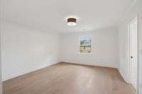 The primary bedroom also features a drum-style light fixture, another beautiful update!  Notice that the crown molding at the ceiling extends into this room, as well!