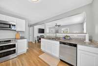 Open Floor plan with updated kitchen(hardwood floors, white cabinets, stainless steel appliances, and granite countertops).