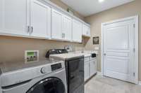 Huge laundry/mud room with cabinetry and sink