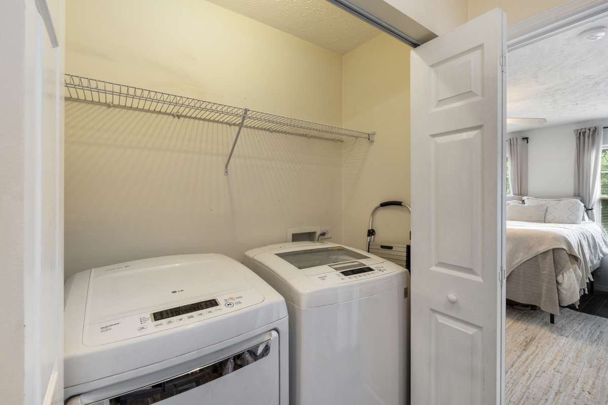 The utility room is located off the primary bedroom. Complete with overhead racks for storage, and utility hookups.