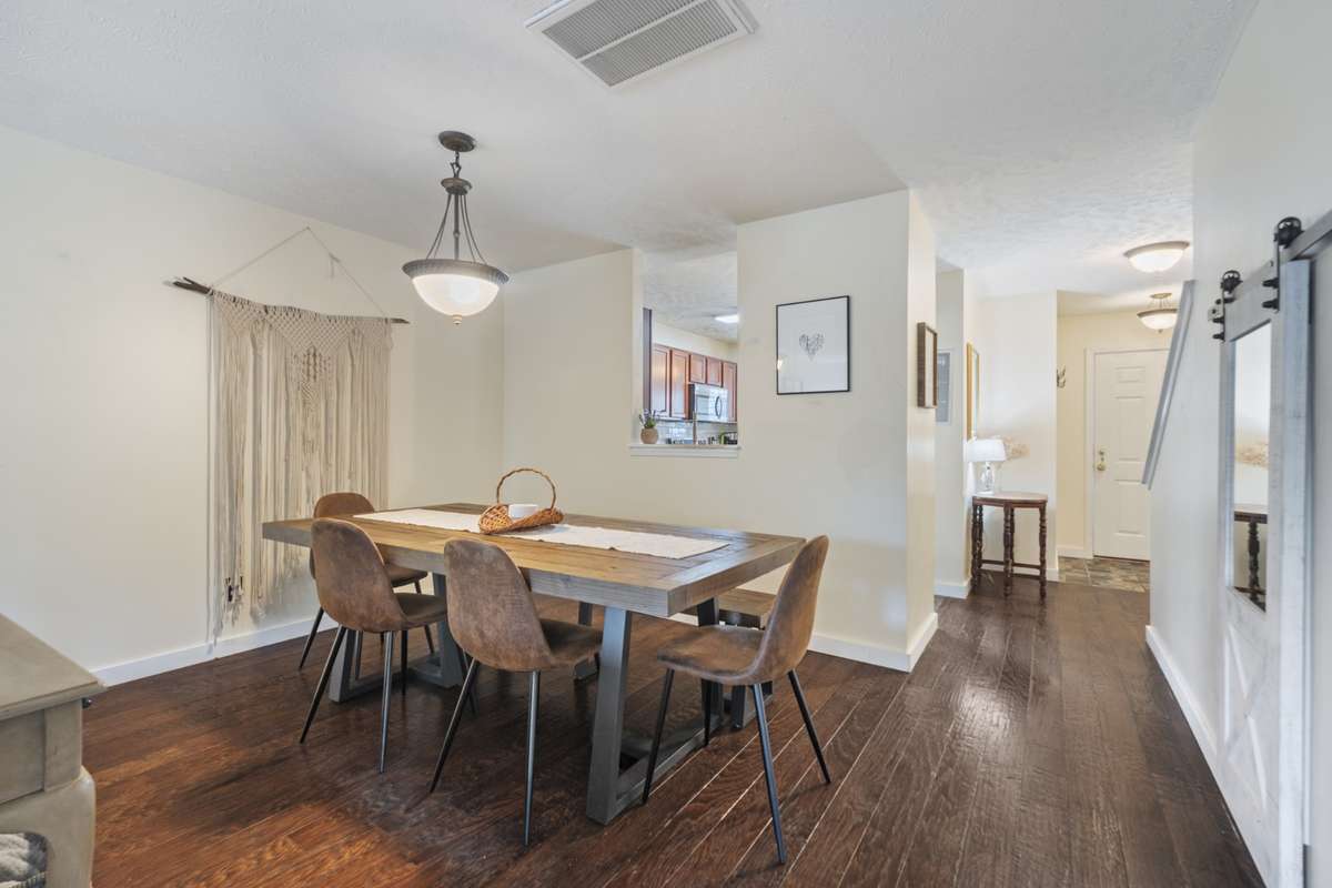 The large living area offers space for a large dining table and includes a beautiful overhead hanging light fixture to add to the space.