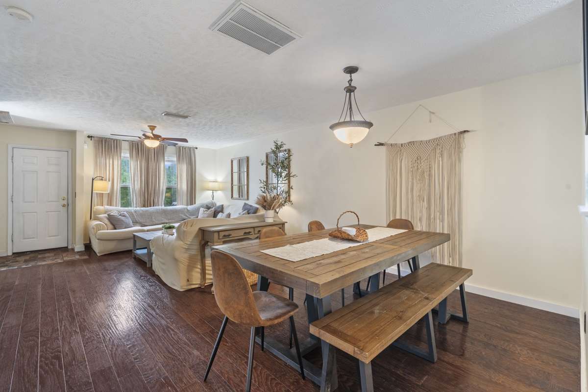 The large living area offers space for a large dining table and includes a beautiful overhead hanging light fixture to add to the space.