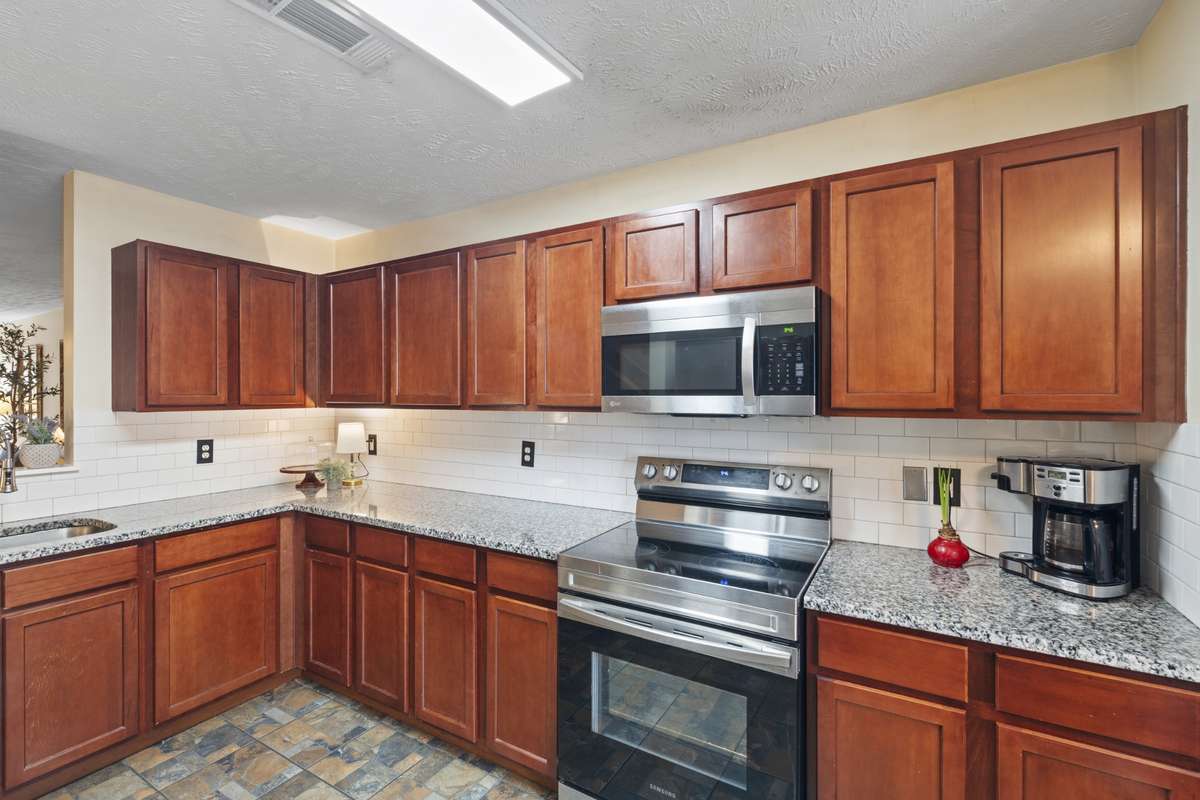 All SS appliances, subway tile backsplash, and unique flooring create an inviting kitchen space where you will enjoy prepping meals.