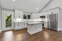 Kitchen with tile backsplash, beautiful island and stainless appliances. (pic from prior listing)