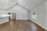 Living area view from dining area. Neutral paint, warm hardwood floors and recessed lighting. (pic from prior listing)