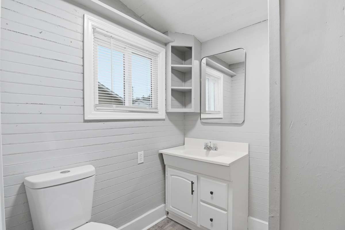 The bathroom has new vanity, mirror, toilet and flooring