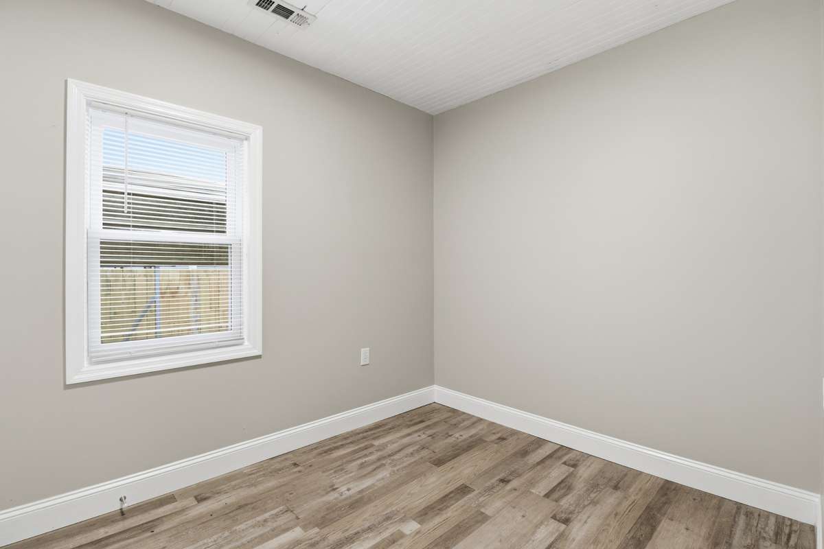 The guest bedroom with new window, light, flooring, sheetrock and paint