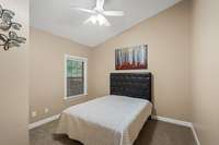 This 12x12 guest bedroom feels spacious and inviting with natural light, fresh carpet, and high slanting ceilings.