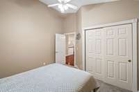 A large closet, a neutral palette, and soaring cathedral ceilings adds function, comfort, and character to this guest bedroom