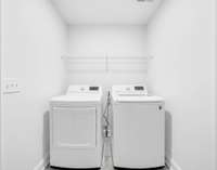 The utility room is located downstairs between the kitchen and the garage. The washer & dryer will remain at no additional cost!