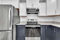 White + navy blue cabinetry & stainless steel appliances.