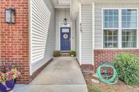 Freshly pressure washed siding & cobalt blue door welcomes you as you make your way to the front porch.