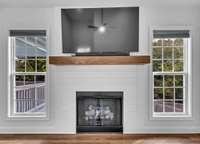 Stylish fireplace surrounded by shiplap + wood mantle + tv! We are move in-ready!