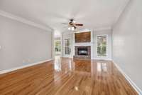 Living room features gleaming hardwood floors and cozy gas log fireplace.