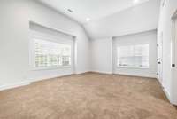 Opposite the primary suite, step into a beautifully oversized, light-drenched bedroom that could easily serve as a bonus room, movie room, workout space, or play area.