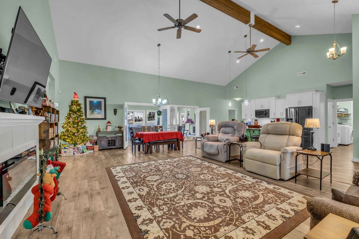 Amazing great room with 20' ceilings featuring beautiful wood beam and LVP floors.
