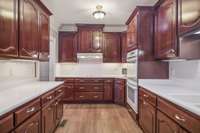 Large Eat in Kitchen with new flooring, an abundance of wood cabinets, neutral counter tops, and under cabinet lighting. All appliances remain.