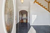 Enter into a two story foyer with pretty floors, crown molding and gorgeous chandelier that is easily cleaned with its electric lift that allows it to be lowered and raised with a push of a button