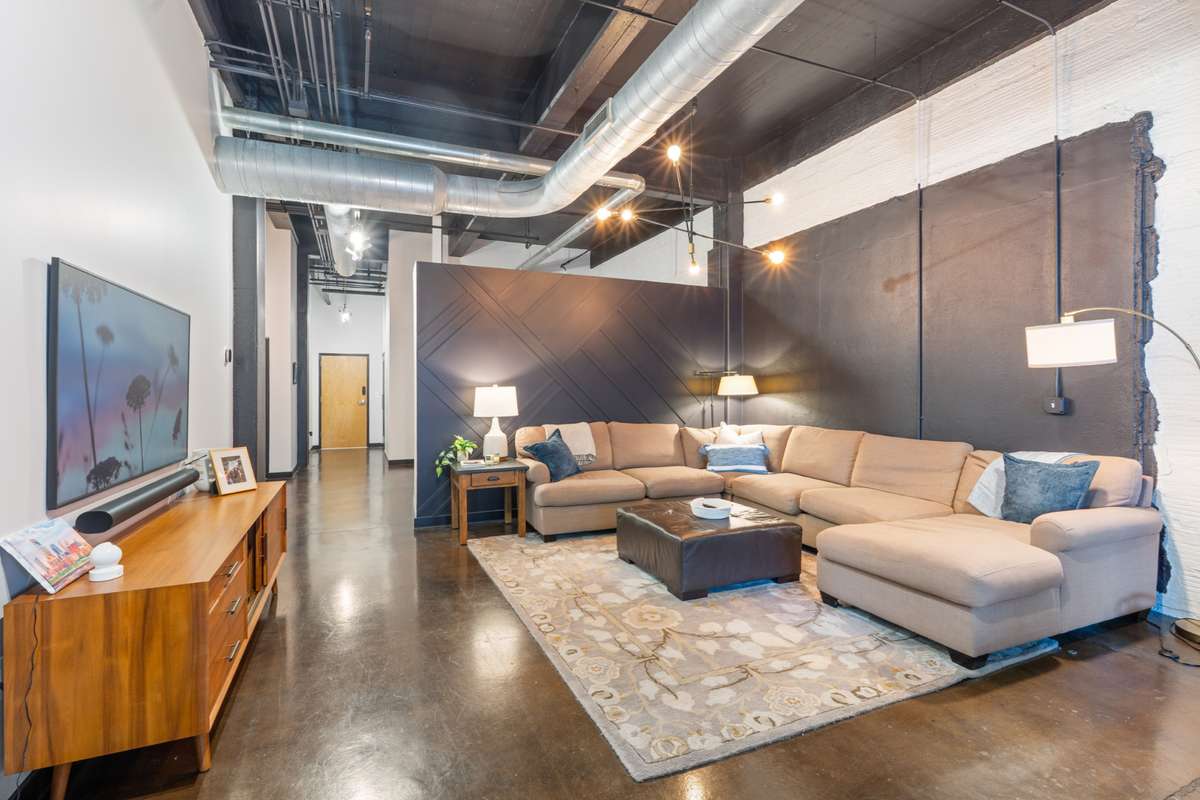 Great room with feature wall and West Elm furniture. Option to purchase unit fully furnished!